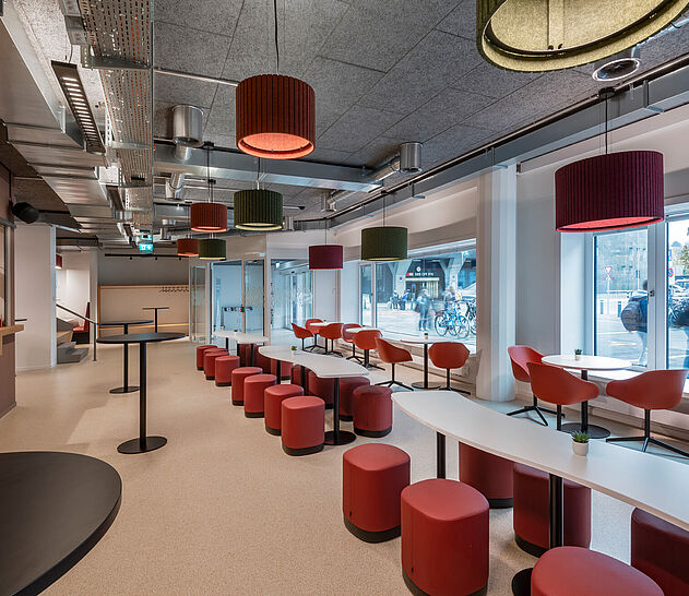 Rote Stühle und Sessel mit Tischlösungen von ZEMP im Café der Uni Luzern.